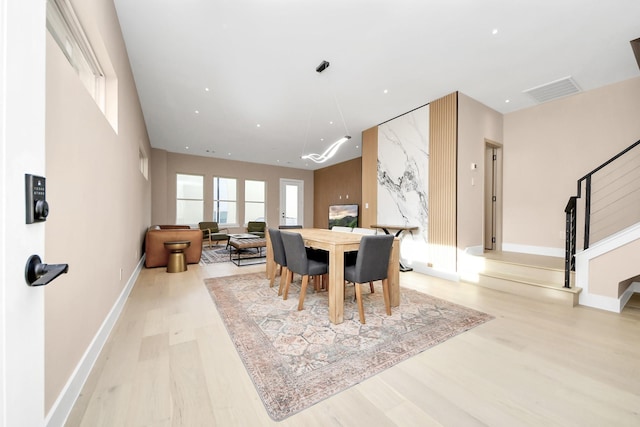 dining room featuring wood finished floors, stairs, and baseboards