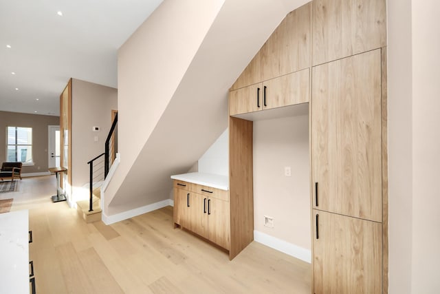interior space featuring light wood-type flooring, baseboards, stairway, and recessed lighting