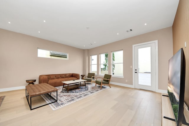living area with light wood finished floors, baseboards, and recessed lighting