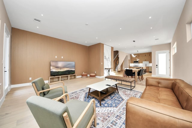 living room with light wood-style floors, baseboards, and recessed lighting