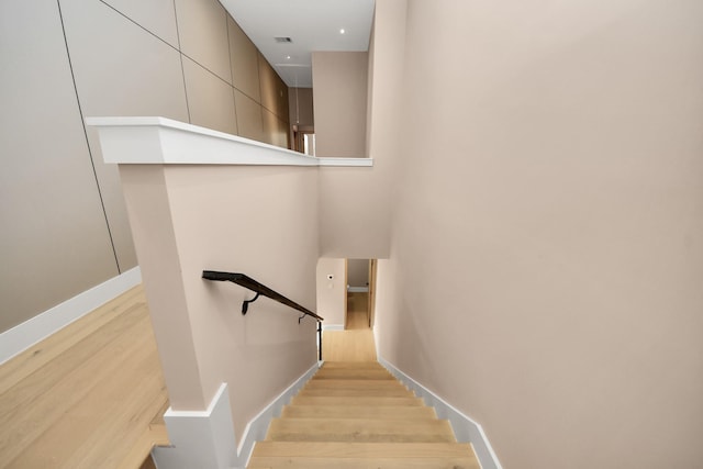 stairs with wood finished floors and baseboards