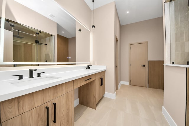 full bathroom featuring a stall shower, double vanity, baseboards, and tile patterned floors