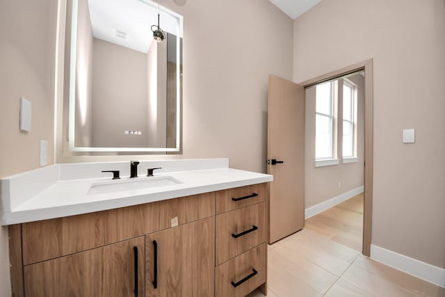 bathroom with baseboards, vanity, and tile patterned floors