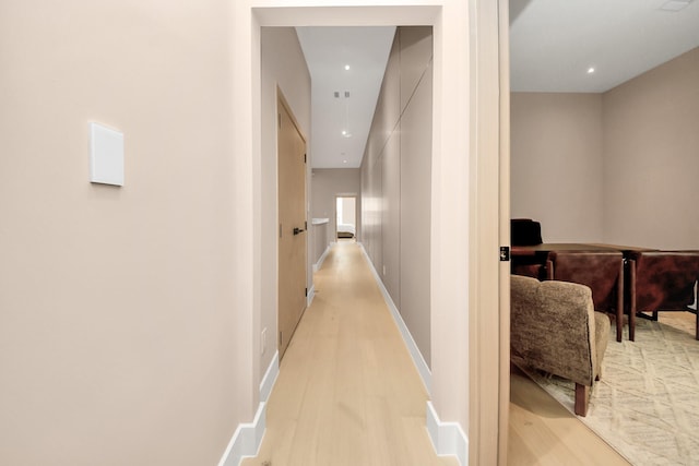 hallway with light wood finished floors, recessed lighting, and baseboards
