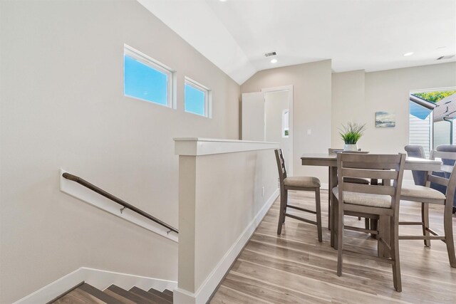 238 Julia St Unit E, Houston, TX 77022 - dining space with baseboards, light wood-style floors, recessed lighting, and vaulted ceiling