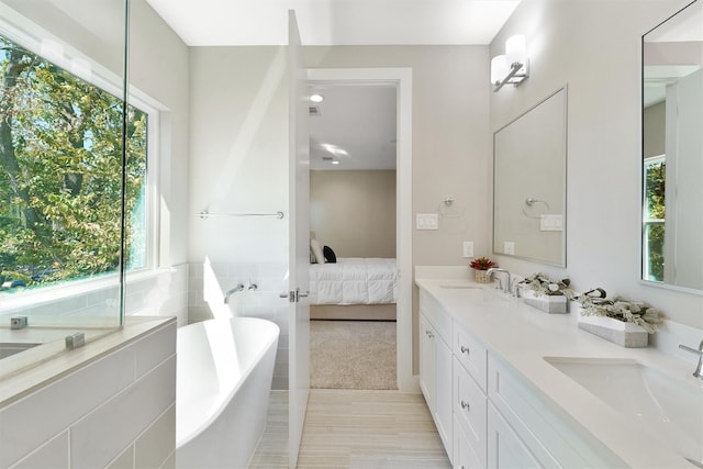 238 Julia St Unit E, Houston, TX 77022 - bathroom featuring a freestanding bath, connected bathroom, and double vanity