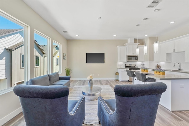 238 Julia St Unit E, Houston, TX 77022 - living area with light wood-style flooring, baseboards, and recessed lighting