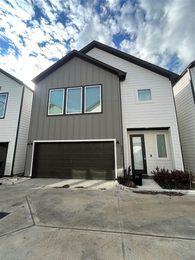 238 Julia St Unit E, Houston, TX 77022 - view of front of property featuring a garage, board and batten siding, and concrete driveway