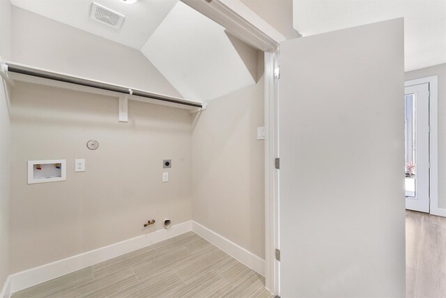 238 Julia St Unit E, Houston, TX 77022 - clothes washing area with gas dryer hookup, washer hookup, hookup for an electric dryer, baseboards, and light wood-type flooring