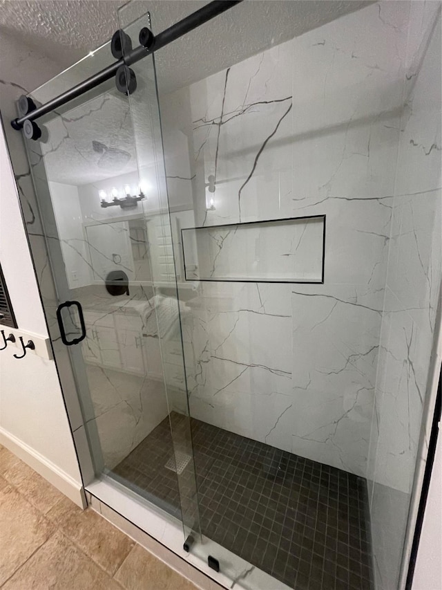 13537 Laramie Trl, Montgomery, TX 77316 - full bathroom with a marble finish shower, tile patterned floors, a textured ceiling, and baseboards