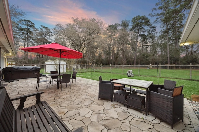 13537 Laramie Trl, Montgomery, TX 77316 - patio terrace at dusk with outdoor dining area, a hot tub, view of wooded area, and grilling area