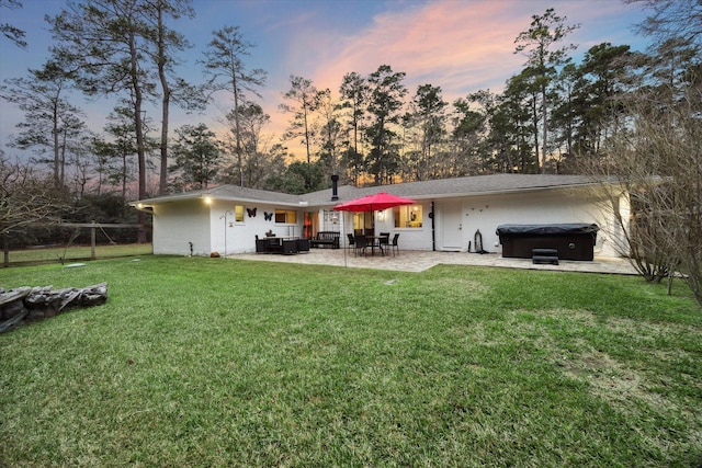 13537 Laramie Trl, Montgomery, TX 77316 - back of house at dusk featuring a hot tub and a patio area