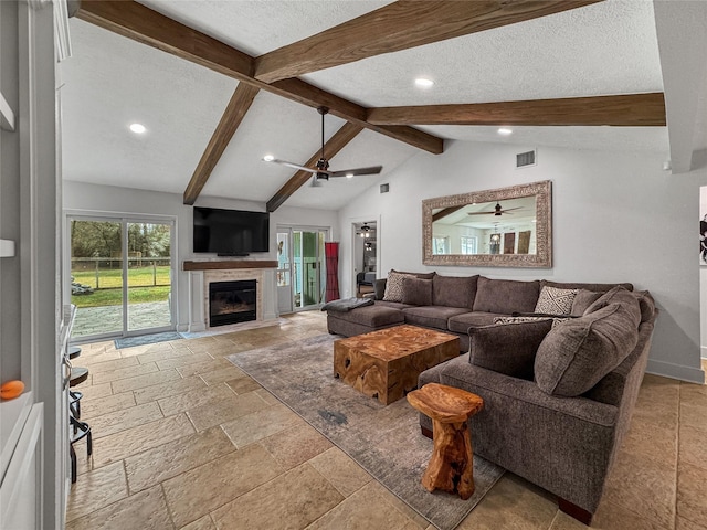 13537 Laramie Trl, Montgomery, TX 77316 - living room with a ceiling fan, recessed lighting, stone tile floors, a glass covered fireplace, and a textured ceiling