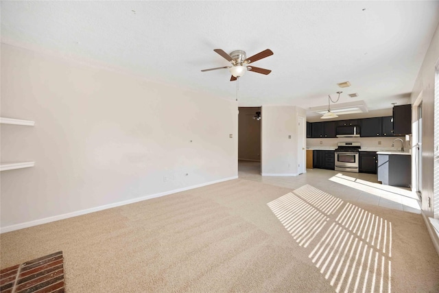 17610 Mill Springs Dr, Spring, TX 77379 - unfurnished living room with a ceiling fan, baseboards, light carpet, and a sink