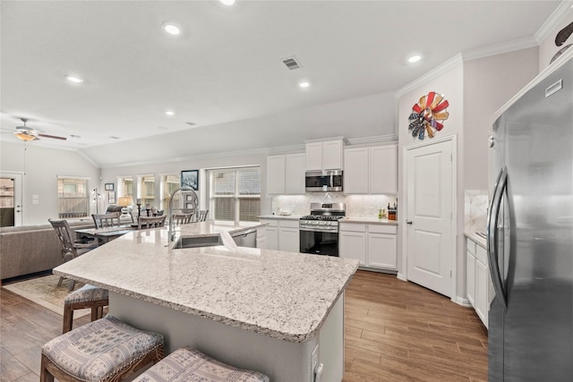 20122 Matador Ridge Dr, Cypress, TX 77433 - kitchen with stainless steel appliances, a sink, vaulted ceiling, ceiling fan, and decorative backsplash
