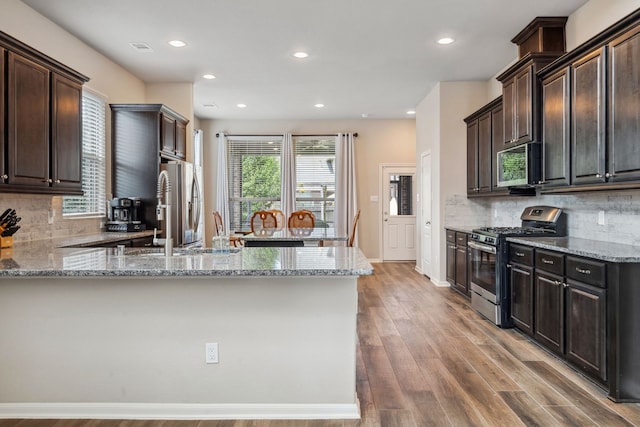 237 Catoti Cay Ct, Conroe, TX 77304 - kitchen featuring stainless steel appliances, light stone countertops, a sink, a peninsula, and recessed lighting