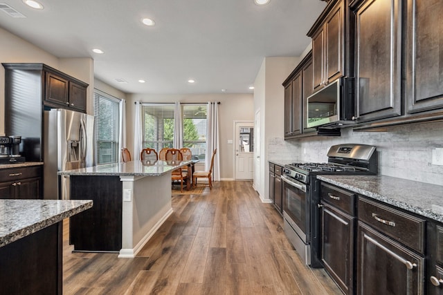 237 Catoti Cay Ct, Conroe, TX 77304 - kitchen featuring stainless steel appliances, baseboards, dark brown cabinetry, dark wood-style floors, and tasteful backsplash
