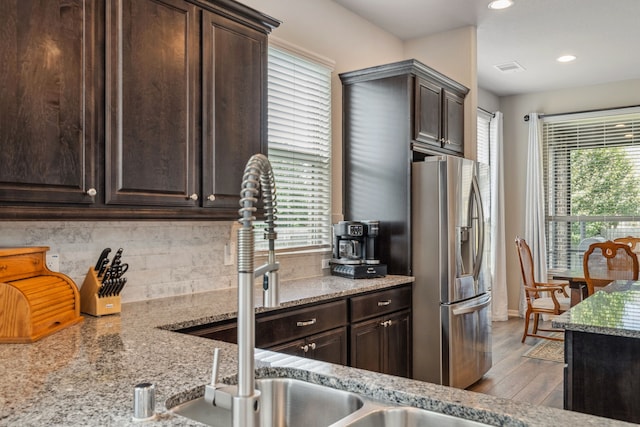 237 Catoti Cay Ct, Conroe, TX 77304 - kitchen featuring stainless steel refrigerator with ice dispenser, plenty of natural light, tasteful backsplash, dark brown cabinets, and recessed lighting