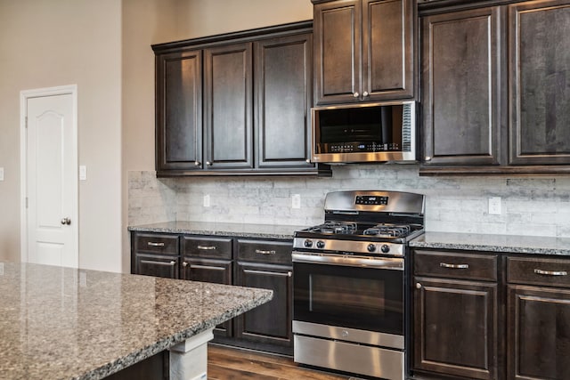 237 Catoti Cay Ct, Conroe, TX 77304 - kitchen with stainless steel appliances, light stone countertops, backsplash, dark wood-style flooring, and dark brown cabinetry