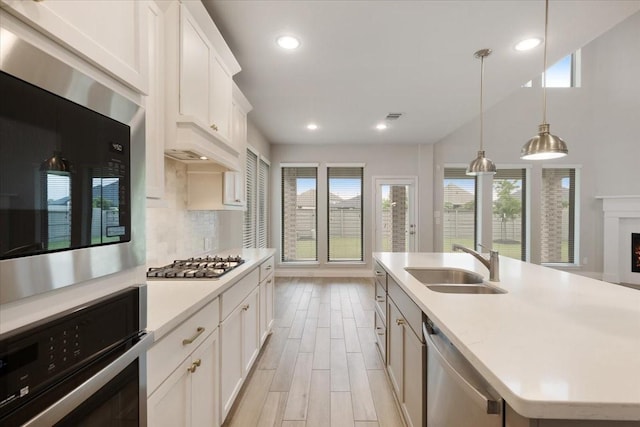 kitchen with black appliances, a sink, plenty of natural light, light countertops, and recessed lighting