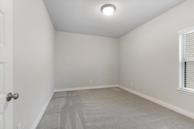 carpeted spare room with baseboards and plenty of natural light