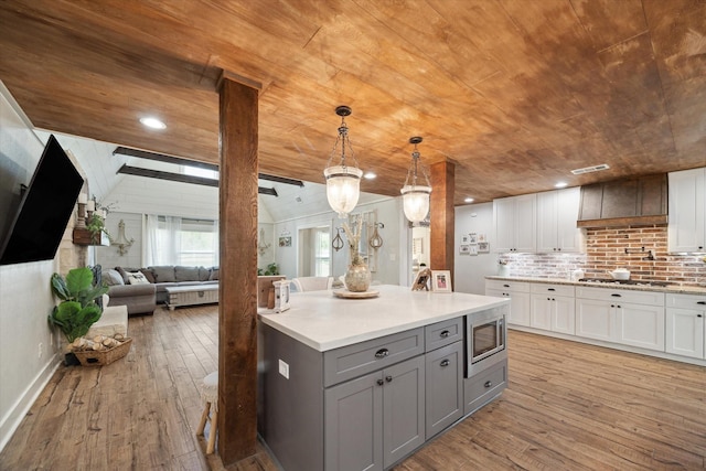 41103 Mill Creek Rd, Magnolia, TX 77354 - kitchen with gray cabinetry, stainless steel microwave, wooden ceiling, light wood-style flooring, and white cabinetry