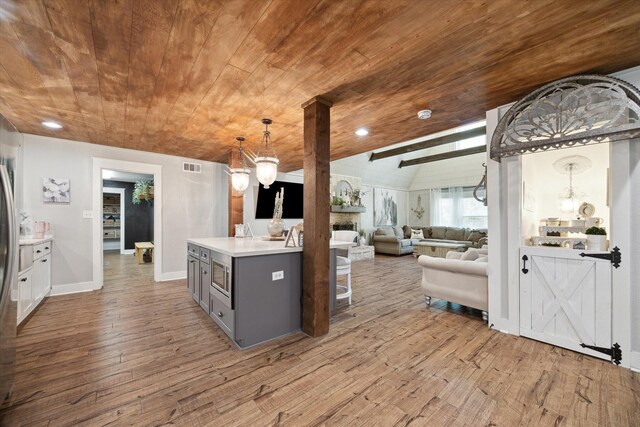 41103 Mill Creek Rd, Magnolia, TX 77354 - kitchen with wooden ceiling, gray cabinetry, light wood-style flooring, light countertops, and stainless steel microwave