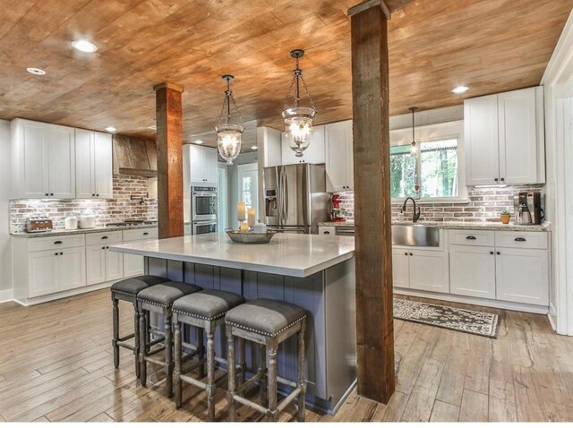 41103 Mill Creek Rd, Magnolia, TX 77354 - kitchen with appliances with stainless steel finishes, wooden ceiling, a sink, decorative backsplash, and light wood-type flooring