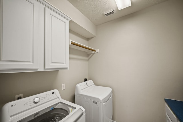 1509 Mcduffie St, Houston, TX 77019 - laundry room featuring cabinet space, separate washer and dryer, and a textured ceiling