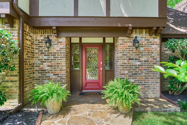 view of exterior entry featuring brick siding