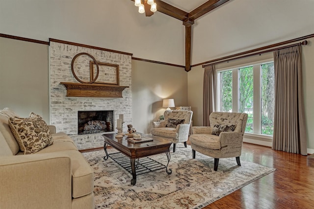 living area featuring a high ceiling, wood finished floors, a fireplace, and baseboards
