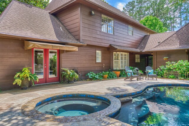 back of house with french doors, a patio, roof with shingles, and a pool with connected hot tub