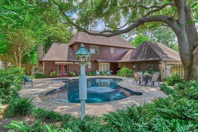 view of swimming pool featuring fence, french doors, and a patio area