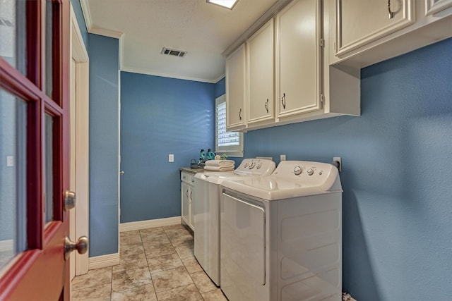 washroom with cabinet space, washer and clothes dryer, ornamental molding, and baseboards