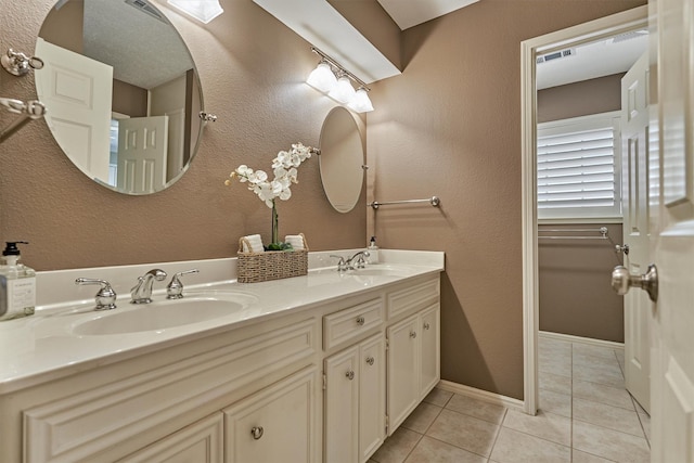 full bath featuring tile patterned floors, double vanity, and baseboards
