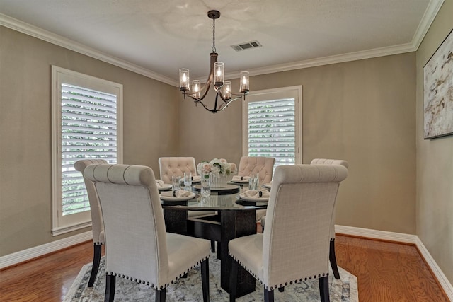 dining area featuring a chandelier, wood finished floors, baseboards, and ornamental molding