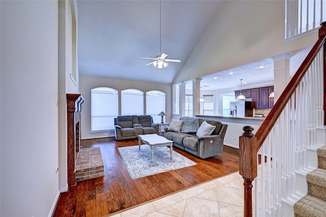 14022 Ashland Landing Dr, Cypress, TX 77429 - living area with stairs, a ceiling fan, decorative columns, wood finished floors, and high vaulted ceiling