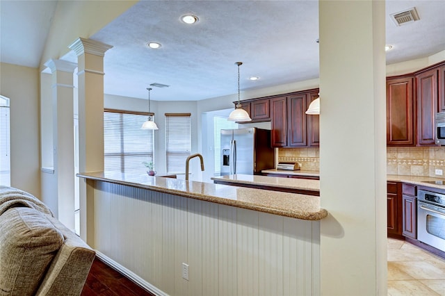 14022 Ashland Landing Dr, Cypress, TX 77429 - kitchen featuring stainless steel appliances, reddish brown cabinets, tasteful backsplash, recessed lighting, and pendant lighting