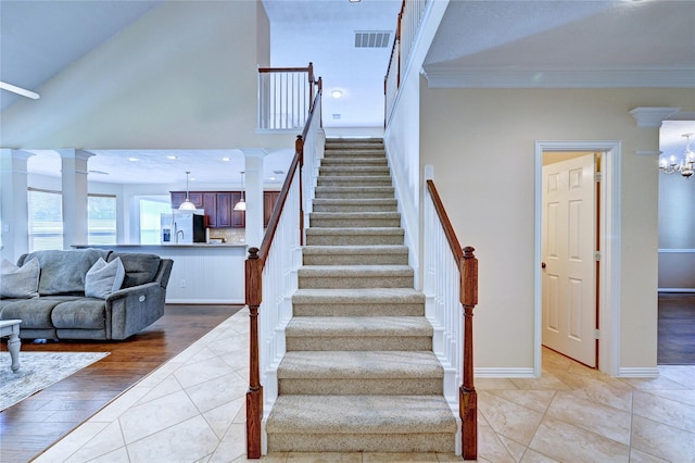 14022 Ashland Landing Dr, Cypress, TX 77429 - stairway featuring ornate columns, crown molding, tile patterned flooring, baseboards, and a chandelier
