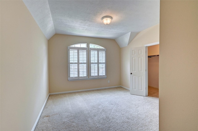 14022 Ashland Landing Dr, Cypress, TX 77429 - unfurnished bedroom with carpet, lofted ceiling, a textured ceiling, baseboards, and a spacious closet