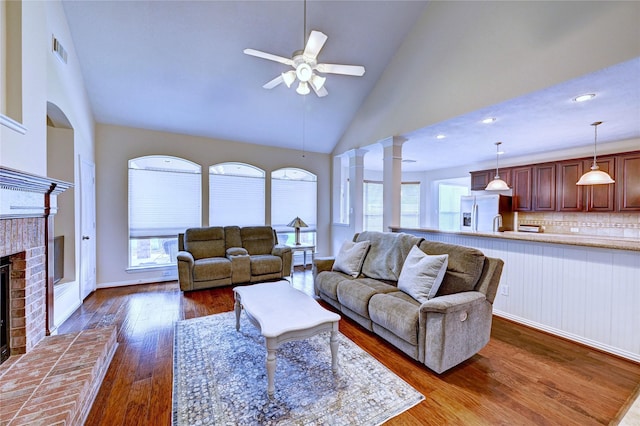 14022 Ashland Landing Dr, Cypress, TX 77429 - living room with a ceiling fan, high vaulted ceiling, dark wood finished floors, decorative columns, and a brick fireplace