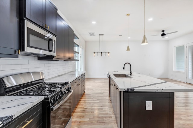 9428 Campbell Rd Unit B, Houston, TX 77080 - kitchen with gas stove, stainless steel microwave, a sink, light wood-style floors, and recessed lighting