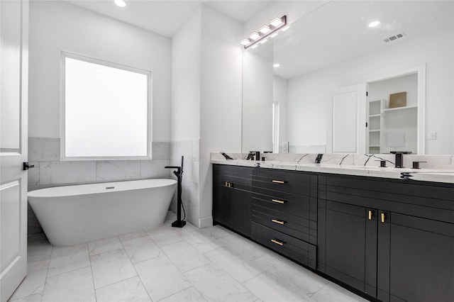 9428 Campbell Rd Unit B, Houston, TX 77080 - bathroom featuring marble finish flooring, double vanity, a soaking tub, wainscoting, and recessed lighting