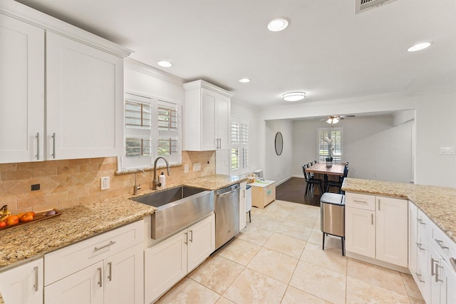 kitchen featuring dishwasher, a sink, crown molding, white cabinetry, and backsplash