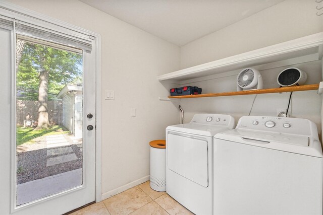 washroom with washing machine and clothes dryer, light tile patterned floors, and baseboards