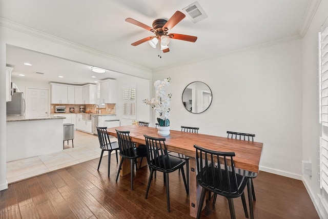 dining room with ceiling fan, light wood-style flooring, crown molding, baseboards, and recessed lighting