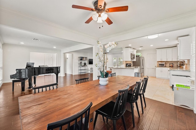 dining space with a ceiling fan, ornamental molding, light wood-style flooring, and recessed lighting