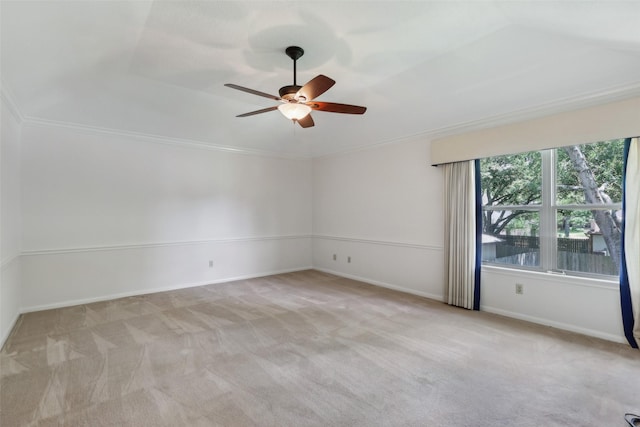 spare room featuring carpet, a ceiling fan, baseboards, and crown molding