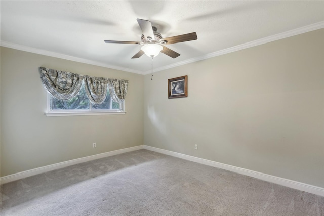 spare room featuring carpet floors, a ceiling fan, baseboards, and crown molding