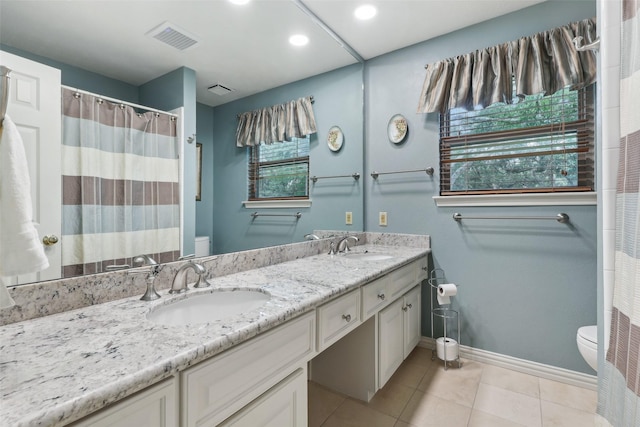 bathroom with toilet, baseboards, double vanity, tile patterned flooring, and recessed lighting